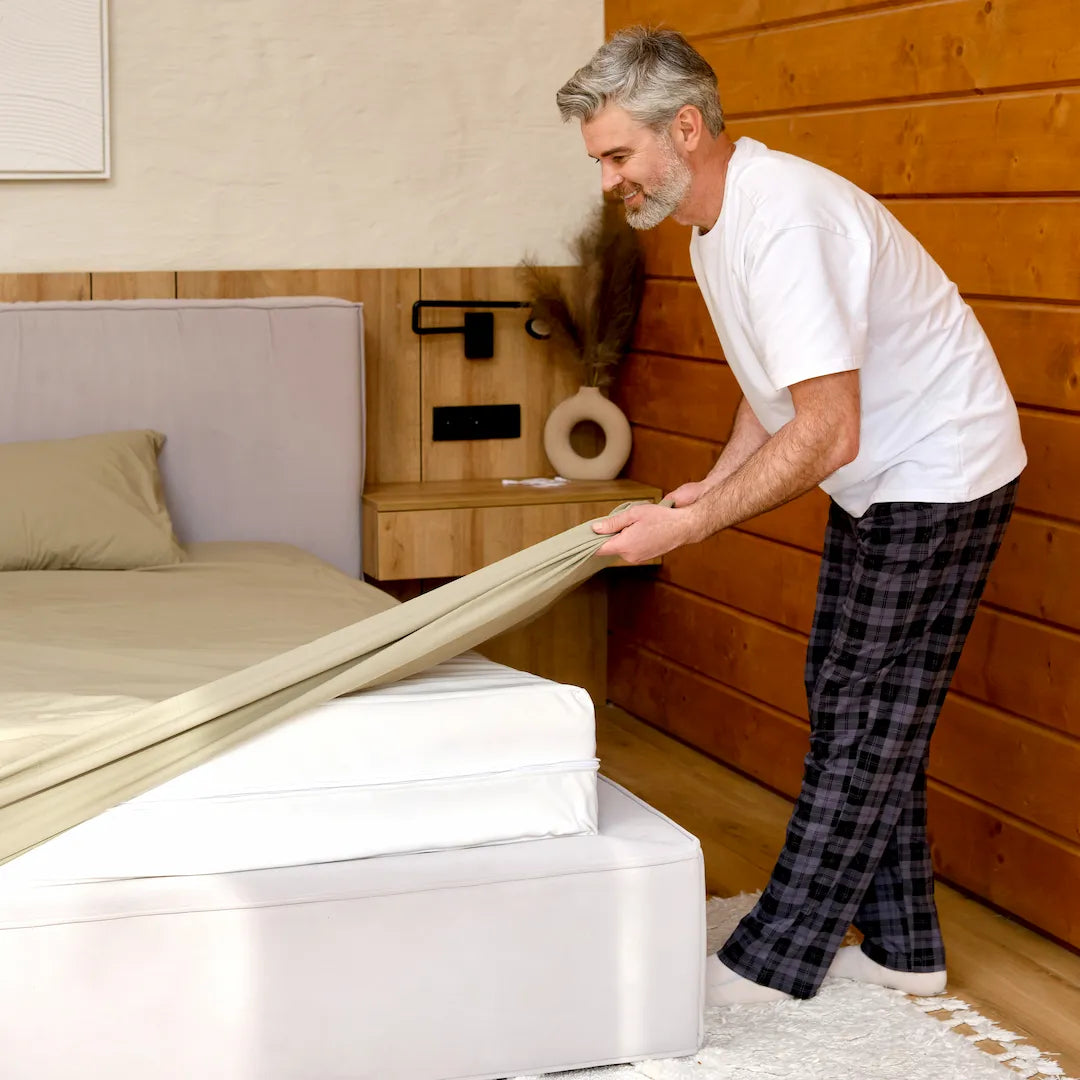 premium grounding bed sheets - Man putting on grounding bed sheets on bed